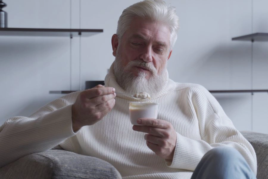 Senior man eating yogurt